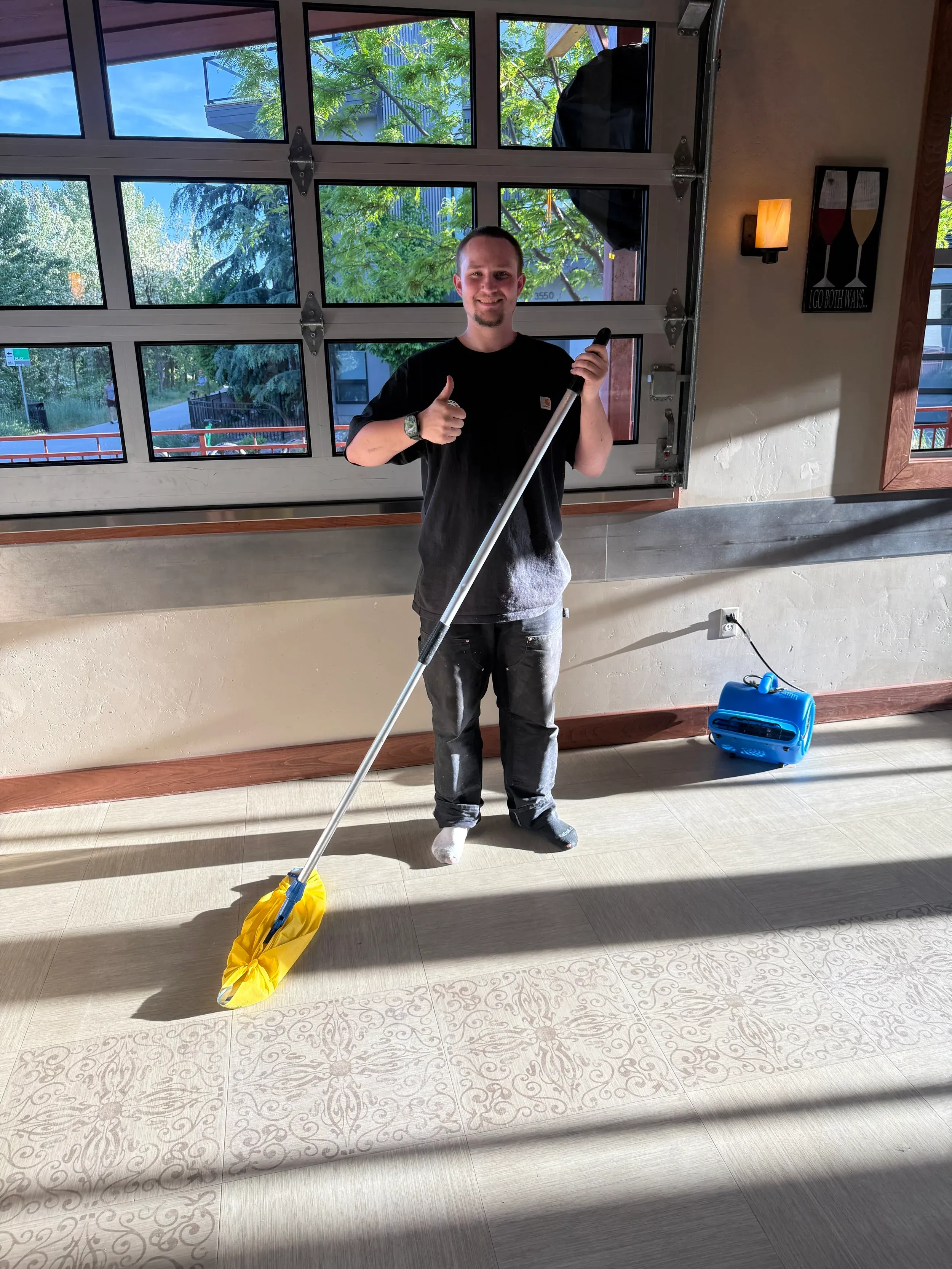 A Rocky Mountain Cleaning Services crew member with equipment inside a commercial building, ready for high dusting.