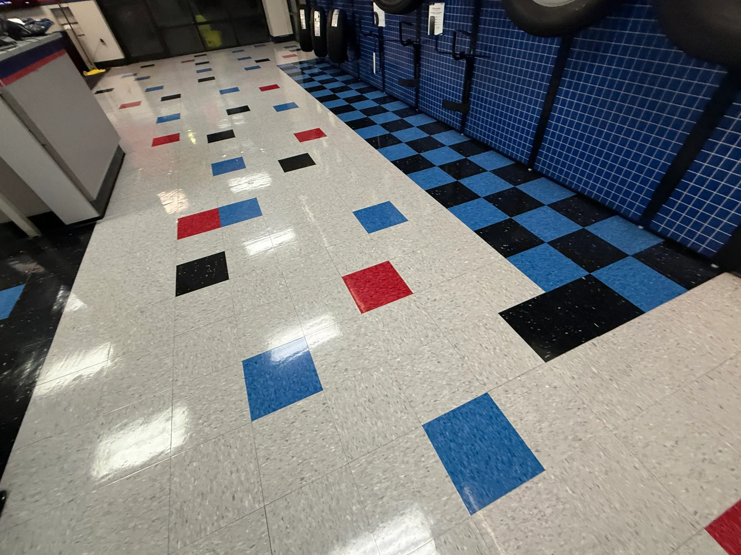 Commercial strip and wax result: a restaurant floor of black and blue checkered tile with a fresh gloss finish.